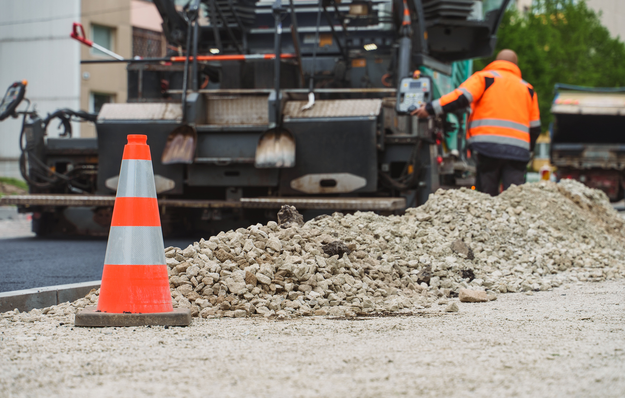 Road paving machine stacking asphalt on the street.