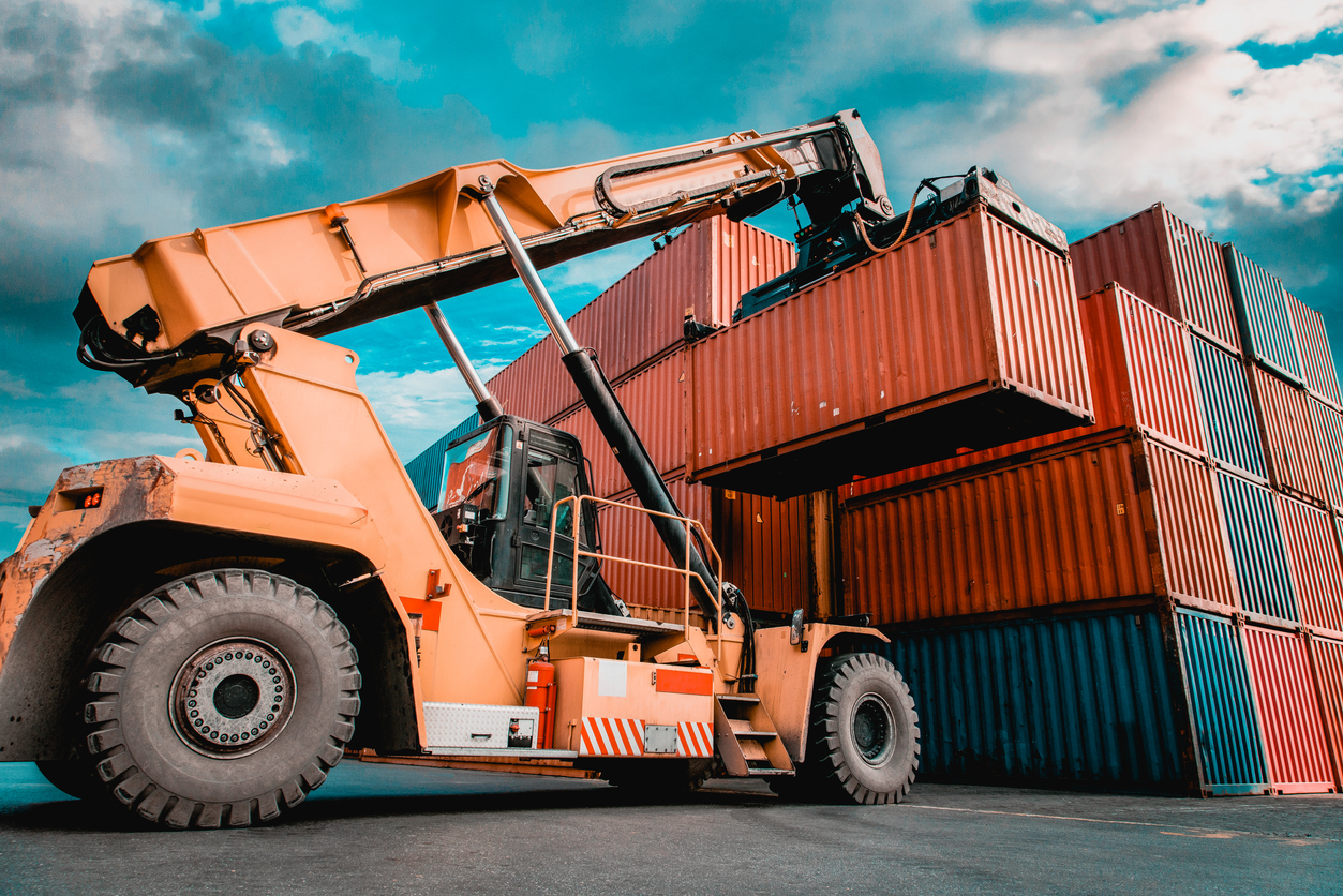 Crane lifting up container in yard