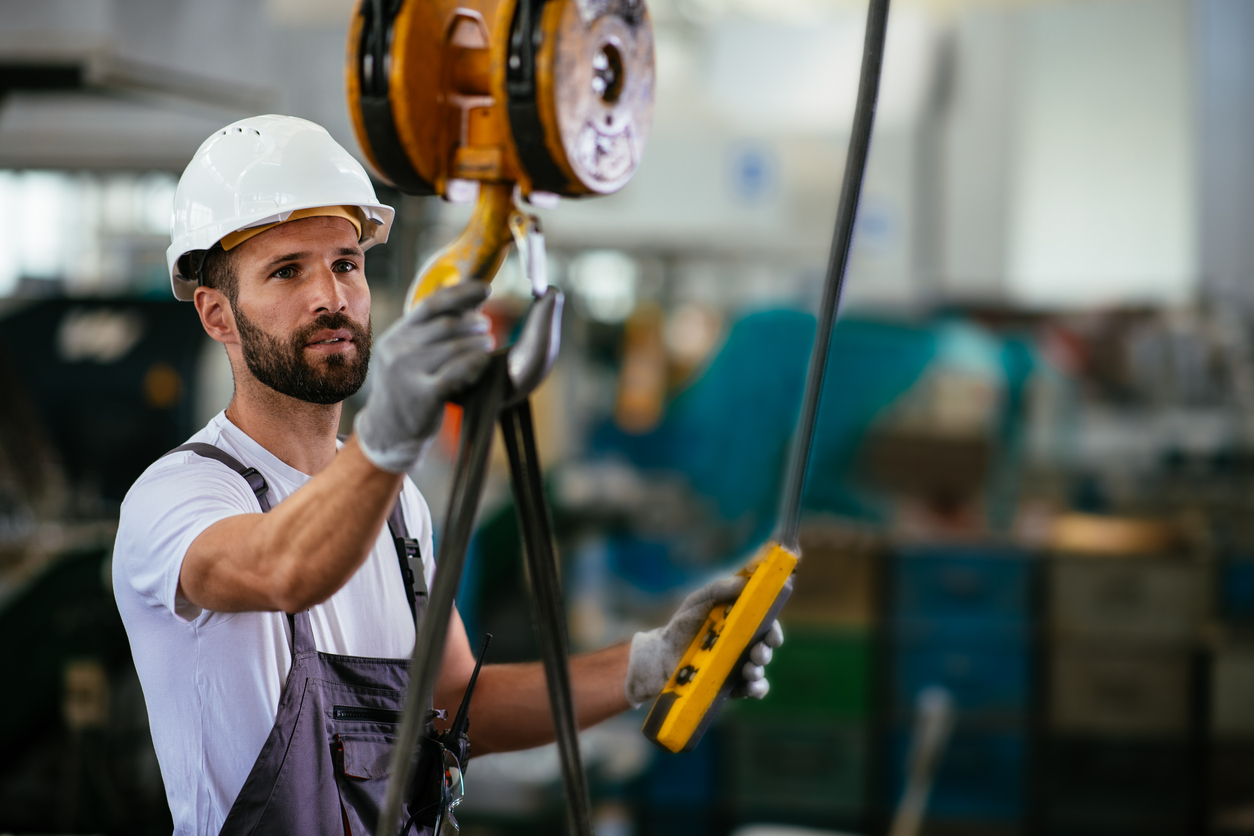 Worker in factory using lifting beam